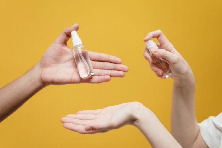 people holding clear glass bottle